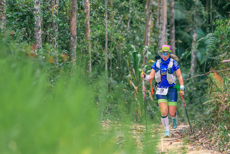 Letícia correndo em trilha na mata